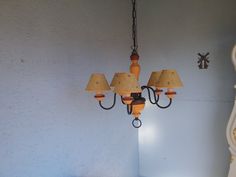 a chandelier hanging from the side of a wall next to a bed and nightstand