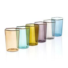 six different colored glass cups lined up in a row