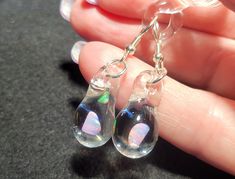 Make a splash with these Mermaid's Tears earrings!  These gorgeous hand-blown teardrop earrings are made with only the highest quality borosilicate glass and features a mesmerizing Gilson opal polished nugget that shimmers with blue, green, yellow, and even a hint of red within the opal encased in glass. These opals flash different colors when angled in different directions and are pictured with sterling silver fishhooks. These blown glass opal earrings come mounted on sturdy sterling silver fis Unique Hypoallergenic Teardrop Dangle Earrings, Unique Iridescent Teardrop Earrings, Iridescent Teardrop Jewelry For Gift, Hypoallergenic Glass Teardrop Jewelry, Iridescent Teardrop Hypoallergenic Jewelry, Iridescent Drop Earrings For Gift, Clear Long Drop Jewelry As Gift, Iridescent Teardrop Earrings For Gift, Opal Teardrop Earrings As Gift