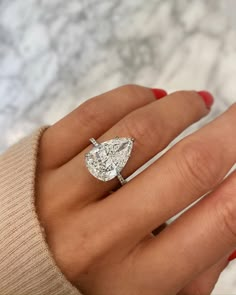 a woman's hand with a diamond ring on it