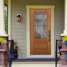 the front door of a house with potted plants on the steps and an entryway