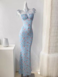 Get ready to turn heads in the Alanis Floral Maxi Dress! This elegant sleeveless dress features a stylish tie-up front detail and adjustable spaghetti straps for the perfect fit. With its backless design and beautiful floral pattern, this dress is perfect for any holiday or sun-filled occasion. Available in both blue and white, you'll rock any event in this versatile and stunning dress. Fitted Summer Maxi Dress With Adjustable Straps, Elegant Halter Dress For Spring, Fitted Sundress With Knotted Straps And Square Neck, Casual Fitted Maxi Dress With Knotted Straps, Fitted Halter Neck Floral Dress, Fitted Floral Dress With Tie Back For Brunch, Casual Floral Print Backless Halter Dress, Fitted Summer Maxi Dress With Tie Straps, Feminine Fitted Sundress With Halter Neck