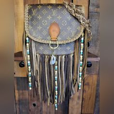 a purse with fringes and beads hanging on a wooden wall