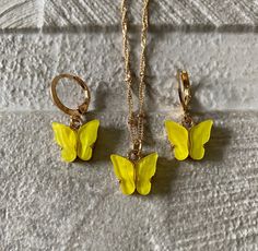 Yellow gold butterfly earrings and necklace set, small butterfly hoop and pendant necklace set, yellow butterfly resin set When you need that little something to finish of an outfit, this beautifully handmade and handcrafted butterfly set will do that.  This set will emphasise your outfit to look simple, delicate and elegant. Please note chains may vary due to stock as they are handmade.  Description:  * Gold / Yellow * 2.5cm - 1.5cm (Earring - 3.5g) estimate * 45cm - 60cm (Chain - 5g) estimate * 2.5 - 1.5cm (Pendant) estimate  * Zinc alloy / Gold finish / yellow coloured resin The necklace set is super light weight.  Beautiful accessory to make any outfit look outstandingly beautiful. The ideal gift for friends, family or even yourself.  Handmade and finished with a high standard. Each pi Gold Butterfly Earrings, Butterfly Resin, Earrings And Necklace Set, Butterfly Earrings Gold, Small Butterfly, Pretty Star, Earrings And Necklace, Yellow Butterfly, Minimalist Gifts