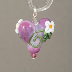 Heart pendant with flowers and vines. Beaded with sterling silver and swarovski crystals. All my beads are properly cleaned They are annealed in a digitally controlled kiln for strength and durability. Each bead is unique Please remember: although every effort is made to create a strong, stable bead, glass is still glass and should be handled with care. The item on the photo is the item sold. I never use stock images or same image for multiple items. We make every effort to provide high quality images to assist you in choosing your item. However, images may vary in color depending on your monitor color settings. If exact color is critical to your order we recommend contacting me by e-mail so I can help you. Thank you for looking at my work Madeleine Ahlström. Whimsical Heart-shaped Jewelry For Crafting, Heart Shaped Spacer Beads Jewelry For Gifts, Whimsical Silver Jewelry With Heart Beads, Gift Jewelry With Flower Charm And Czech Glass, Gift Jewelry With Flower Charm In Czech Glass, Handmade Whimsical Heart Pendant Jewelry, Handmade Heart-shaped Czech Glass Jewelry, Small Frog, Beaded Flowers