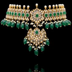 Indulge in the allure of this exquisite jewelry set and let contemporary grace redefine your fashion narrative! Radiate elegance and dangle in delight with our enchanting Esha Set – a mesmerizing blend of elegance and vibrancy meticulously crafted with sparkling zircons, complemented by the refreshing allure of emerald green stones, and embellished with delicately dangling green beads to elevate your style with the perfect harmony of sophistication and playfulness. The set includes a necklace, a maang teekah and a pair of trendy earrings. Approximate earrings length is 3.25". Gold-plated on high-quality brass as base metal. Made by order. Kindly allow 4-6 weeks for the delivery of this item. For custom or urgent requests, please contact support@alacouture.com. *Please Note: We use faux sto Wedding Cubic Zirconia Jeweled Jewelry Set, Luxury Jeweled Wedding Jewelry, Elegant Chandbali Bridal Necklace Hand Set, Luxury Cubic Zirconia Jewelry Sets For Festive Occasion, Elegant Jeweled Jewelry Sets For Reception, Luxury Stone Work Jewelry Sets For Festive Occasion, Elegant Chandbali Jeweled Bridal Necklace, Luxury Stone Work Jewelry For Festive Season, Elegant Festive Sets With American Diamond