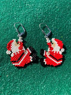 two red and white beaded santa clause earrings on green carpeted area with silver hooks