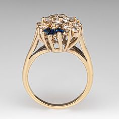 The sophisticated cluster ring is accented with fifteen (15) prong set, round brilliant cut diamonds and six (6) prong set, marquise cut natural sapphires. The ring measures 18.6mm at the top, rises 9.8mm above the finger, tapering to 2.1mm wide and 1.2mm thick at the base of the shank. Several of the diamonds are lightly chipped but nothing that can be seen without magnification. It is currently a size 6. Marquise Cut Multi-stone Diamond Ring For Anniversary, 14k Gold Cluster Diamond Ring With Prong Setting, Cubic Zirconia Marquise-cut Multi-stone Diamond Ring, Marquise Cut Multi-stone Cubic Zirconia Diamond Ring, Multi-stone Cubic Zirconia Marquise Cut Ring, Marquise Multi-stone Cluster Ring For Anniversary, Marquise Multi-stone Cluster Ring For Formal Occasions, Anniversary Marquise Cut Multi-stone Cluster Ring, Timeless Multi-stone Diamond Ring For Wedding