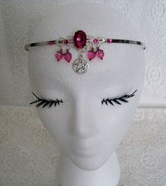 This beautiful circlet has a sterling silver plated filigree pendant with pink faceted glass setting, rhinestones, pewter silver pentacle, pink faceted beads, sterling silver plated bead caps and seed beads. Adjustable. Adjustable Wire Wrapped Fantasy Jewelry, Fantasy Wire Wrapped Jewelry For Festivals, Silver Crown Shaped Metal Jewelry, Silver Metal Crown-shaped Jewelry, Silver Crown-shaped Metal Jewelry, Handmade Pink Gothic Jewelry, Adjustable Silver Wire Wrapped Body Jewelry, Adjustable Silver Spiritual Body Jewelry, Gothic Adjustable Body Jewelry For Festivals