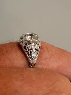 A wonderful Victorian band with great filigree detail. The center stone measures out at .80 ct and has a clarity of SI1 and G color. There is a small natural crystal on the girdle. On either side are 2 @.05ct diamonds set in diamond shape gold. The band weighs 2.5 grams and is is excellent condition. It measures 8.5mm across the top. Ornate Diamond White Filigree Jewelry, Vintage Diamond Jewelry With Intricate Design, Ornate Filigree Diamond White Jewelry, Ornate Diamond White Jewelry With Filigree, Ornate Formal Jewelry With Single Cut Diamonds, Ornate Platinum Jewelry, Ornate Diamond Jewelry With Intricate Design, Antique Jewelry In Diamond White With Brilliant Cut, Diamond White Oval Filigree Jewelry