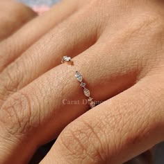 a woman's hand with a diamond ring on top of her finger and the other hand holding it