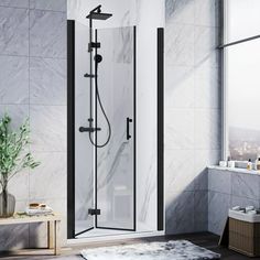 a bathroom with a walk in shower next to a window and rug on the floor