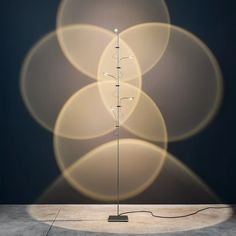 a lamp that is sitting in the middle of a room next to a wall with circles on it