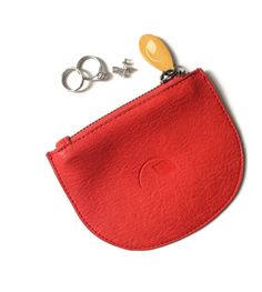 a small red pouch with two keys in it