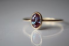 This lovely Lab-Created oval 6x4mm Alexandrite ring has a rich, romantic feel to it. I have set this 6x4mm stone into a solid 14k bezel cup. The 18 gauge band has been also highly polished for a very reflective shine to add to this sparkly stone. This style ring has an open back to allow light to pass through the stone. Material Information: Clarity: Occlusion free Color: Green, blue, purple Gemstone: Lab-Created oval 6x4mm Alexandrite  Metal: 14k yellow gold ★ IMPORTANT SHIPPING & PRODUCTION DE Oval Alexandrite Ring, Elegant Oval Sapphire Ring With Bezel Setting, Elegant Oval Ruby Ring For Proposal, Oval Sapphire Ring In Yellow Gold For Proposal, Elegant Oval Bezel Set Birthstone Ring, Elegant Oval Ruby Ring With Bezel Setting, Oval Ruby Ring With Bezel Setting For Wedding, Oval Bezel Set Engagement Ring, Stacked Rings Aesthetic