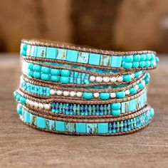 The contrast between blue and turquoise with silvery colored beads inspires soothing elegance. Women artisans from Guatemala's Weaving Hands of Atitlan craft the wrap bracelet by hand with dark brown cords. Artisan Blue Adjustable Wrap Bracelet, Artisan Turquoise Hand Wrapped Wrap Bracelet, Artisan Hand Wrapped Turquoise Wrap Bracelet, Artisan Turquoise Wrap Bracelet For Festivals, Artisan Blue Wrap Bracelet As A Gift, Turquoise Beaded Bohemian Wrap Bracelet, Artisan Blue Wrap Bracelet Gift, Blue Spiritual Wrap Bracelet For Festival, Adjustable Turquoise Beaded Artisan Bracelets