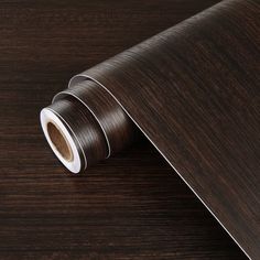 a dark brown woodgrain wallpaper with white trim on the bottom and sides