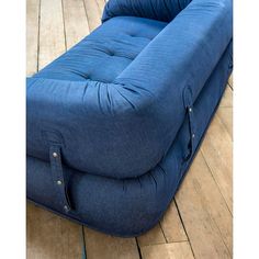 a blue couch sitting on top of a wooden floor