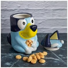 a blue and white dog mug next to some peanuts