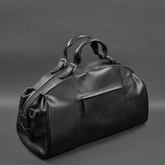 A leather travel bag is a comfortable and roomy model that will allow you to take everything you need with you on a business trip or a short trip. Key Features: The bag is made of smooth genuine leather of premium quality. Strong textile lining inside. The accessory closes with a zipper, which is fixed with whips. The bag has one roomy compartment and several pockets for small items. The bag has comfortable leather handles. The set includes a removable wide shoulder strap. The bottom is protecte Elegant Soft Leather Travel Bag For On-the-go, Classic Travel Briefcase With Leather Handles, Black Luxury Travel Accessories For On-the-go, Timeless Travel Bag With Leather Handles For Everyday Use, Classic Large Capacity Bag For On-the-go, Classic Large Capacity Bags For On-the-go, Classic Travel Briefcase Tote, Classic Weekender Bag With Luggage Sleeve For Travel, Classic Travel Tote Briefcase