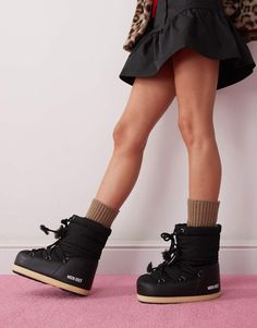 a woman's legs and shoes are shown in front of a white wall with pink carpet