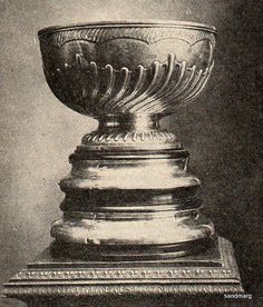 an antique photo of a silver cup on display