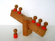 a wooden toy with red knobs on it's sides and an orange one in the middle