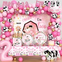 a pink and black cow theme for a baby shower party with balloons, streamers, plates, cups, and decorations