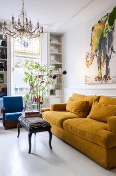 a living room filled with furniture and a painting on the wall