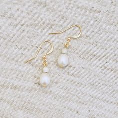 Gold plated white natural freshwater pearl drop earrings alongside a sterling silver stardust bead. Beautifully simple! Gold plated, beautiful white natural potato shaped small freshwater pearl drop earrings. The wire through the pearl itself is gold plated as well as the earring hook. Drop length is approx 1.2/1.3cm as these are natural pearls each pair will differ slightly in drop length and look due to the nature of natural pearls. Please watch the video which shows how beautifully these pear Nickel-free Minimalist Pearl Earrings, Hypoallergenic Drop Pearl Earrings Dainty Style, Dainty Pearl White Earrings, Everyday Minimalist Pearl Drop Teardrop Earrings, Everyday White Pearl Pendant Earrings, Dainty Drop Pearl Earrings Hypoallergenic, Dainty Teardrop Pearl Earrings For Everyday, Pearl White Teardrop Earrings For Everyday, Everyday Pearl White Teardrop Earrings