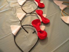 three red and white headbands with hearts on them sitting on top of a table