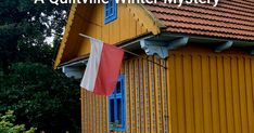 a yellow house with a red and white flag hanging from it's side