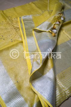 This elegant tissue linen drape in a beautiful gold tone features the beautiful and meticulously done floral cutwork design. This saree has pretty faux mirror (flattened sequin discs) work which adds a lovely vibe and bling to the whole outfit. The saree might have slight irregularities in the pattern & colors, which results from the human involvement in the process & is a hallmark of handcrafted products. Minor thread pulls are not considered damage. We recommend professional dry cleani Gold Slub Silk Traditional Wear With Chikankari Embroidery, Gold Chikankari Embroidery Slub Silk Traditional Wear, Designer Tussar Silk Gold Kurta, Designer Gold Tussar Silk Kurta, Gold Cotton Silk Kurta With Chikankari Embroidery, Gold Kurta With Chikankari Embroidery In Cotton Silk, Festive Linen Traditional Wear With Resham Embroidery, Gold Tussar Silk Kurta With Chikankari Embroidery, Yellow Tissue Silk Kurta With Zari Work