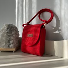 Clip-On Mini Bag Combining elegance and sophistication, the Clip-On Mini Bag is ready to accompany you in every moment. With its natural and handmade details, this bag will add a unique touch to your style. * Dimensions: 6cm x 14cm x 18cm  * Material: Made from durable and high-quality woven material  * Details: Vibrant red color with a detachable strap Features: * Natural and Stylish: Handmade design with natural materials, both eco-friendly and stylish.  * Ease of Use: Ideal for daily use, pra Luxury Handmade Natural Shoulder Bag, Luxury Natural Colored Bag As A Gift, Elegant Natural Box Bag For Travel, Luxury Natural Color Bag As Gift, Luxury Natural Color Bag For Gift, Elegant Crochet Bag With Removable Pouch For Everyday, Rectangular Natural Bucket Bag For Evening, Elegant Handwoven Bags, Luxury Natural Color Bags For Gifts