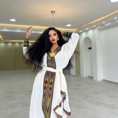 a woman with long black hair wearing a white dress and holding her hands up in the air