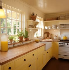 a kitchen filled with lots of yellow cabinets and counter top next to a white stove top oven