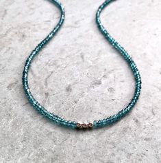 "London Blue Topaz Choker A simple string of translucent teal gemstones encircles the neck, highlighted by three 14K gold filled or sterling silver beads at the front. Simple and charming, a casual piece for everyday wear, easy to dress up. Beautiful blue/teal beads are faceted to capture the light. Versatile design, in your choice of length - also makes a nice wrap bracelet! In your choice of finish and length - extender chain also available. Please measure your neck and/or wrist before orderin Minimalist Single Strand Blue Beaded Necklace, Blue Single Strand Minimalist Beaded Necklaces, Blue Minimalist Necklace With Spacer Beads, Minimalist Blue Necklaces With Spacer Beads, Blue Minimalist Necklaces With Spacer Beads, Blue Gemstone Beaded Minimalist Necklace, Minimalist Blue Gemstone Beaded Necklaces, Minimalist Blue Gemstone Beaded Necklace, Teal Gemstones