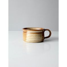 a brown and white cup sitting on top of a table