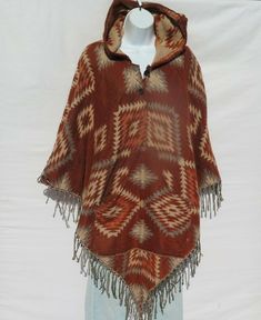 One-of-a Kind !!!…Unique Yak Wool Tasseled Fringe 2 Button Poncho with a Hoodie and Pockets…!!! …Slip on a soft, ultra warm Yak Wool Blend Unisex Poncho on a cool, breezy Autumn day or night… Each 2 Button Neck-Line Yak Wool Blend Poncho is handmade from the Yak Wool Shawls/Throws sold by Tribal Designs by Neela.   --  Each Poncho is Unique --  Handcrafted  --  Design cut from our Yak Wool Blend Shawls Handloomed by Artisans --  One Size Fits Most --  Tassel/Fringe on front side of each Poncho - Bohemian Hooded Poncho For Fall, Casual Brown Poncho For Festival, Bohemian Brown Poncho For Festivals, Hippie Brown Poncho For Festivals, Brown Bohemian Poncho For Festivals, Hippie Brown Poncho For Winter, Bohemian Brown Outerwear With Tassels, Folk Style One-size Poncho For Winter, Handmade Alpaca Bohemian Poncho