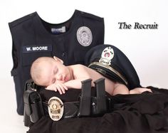 a baby sleeping on top of a police uniform