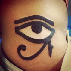 an egyptian eye tattoo on the side of a woman's stomach is shown in black ink