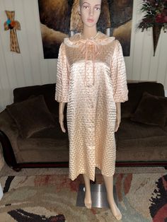 "1960's Vintage \"Vanity Fair\" Women Size Medium Peach Color Elegant Robe. This is a beautiful elegant robe that feels like silk against your skin. This is in MINT condition with NO tears or stains on the fabric Robe Details: 1.) Breast:42\" inches 2.) Shoulder to shoulder: 15\" inches 2.) Shoulder to hem: 43\" inches 4.) Sleeve Length: 23\" inches (Puffy Sleeves) 5.) Waist: 42\" inches 6.). Hip/ Thigh: 50\" inches 7.) 2 pockets 8.) 6 clear with floral design buttons 9.) 100% Acetate 10.) Label Vintage Long Sleeve Robe For Spring, Fitted Vintage Robe For Daywear, Fitted Formal Robe For Spring, Silk Evening Robe For Spring, Vintage Spring Loungewear Robe, Spring Vintage Robe For Loungewear, Spring Vintage Loungewear Robe, Vintage Long Fitted Robe, Vintage Long Sleeve Robe For Daywear