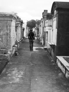 black and white photograph of a person walking in an old cemetery