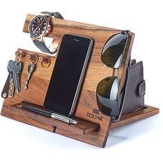 a cell phone, sunglasses, watch and keys in a wooden holder