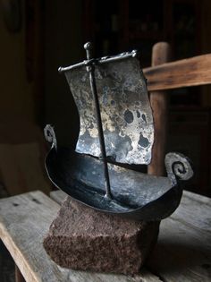 a metal boat sitting on top of a wooden table