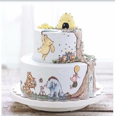 two tiered cake decorated with winnie the pooh characters