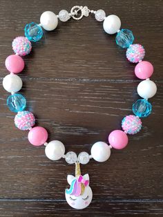 "Unicorn Inspired Chunky Bubblegum Bead Children's Necklace This Unicorn themed necklace will bring a smile to your little one's face! This will make a lovely party favor or gift for birthdays or just as an everyday accessory. Made with primarily 20mm bubblegum beads in shades of blue, pink, blue and white. The necklace measures approximately 11\" when toggled around neck including the unicorn pendant. The bracelet is made with elastic and doubled up for strength. This necklace is great for all Fun Adjustable Beaded Necklace For Birthday, Fun Adjustable Beaded Necklaces For Birthday, Fun Adjustable Beaded Necklaces For Birthdays, Fun Beaded Necklace For Birthday, Playful Colorful Beads Necklaces For Birthday, Fun Round Beads Necklace For Birthday, Playful Colorful Beads Necklace For Birthday, Fun Pink Necklace For Birthday, Fun Beaded Birthday Necklace