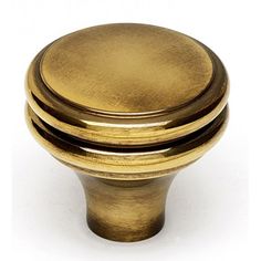 an antique brass cabinet knob on a white background