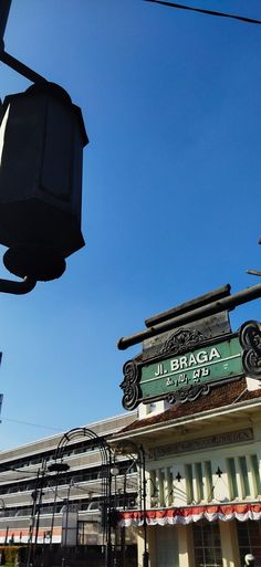 a street light sitting in front of a building with a sign on it's side