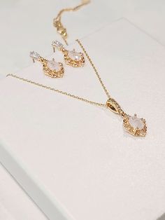 High quality champagne gold plated crystal earrings and necklace set with beautiful frosted white cubic zirconia stones. The chain is 1mm thick and 46cm long. It is easily adjustable to make it shorter to your desired length simply by pulling on the chain through the round gold bead. It also has 2 removal options - using the clasp or pulling the chain out of the round gold bead as shown in the pictures. There are 2 jewelry box options: Box A: regular jewelry cardboard box with a textured diamond pattern on the outside (comes in white, black or red) Box B: Velvet earring and necklace box (comes in green, red and grey) You can also add a mini gift bag as show in the pics: comes with green, red or grey satin ribbon and a few sheets of gift tissue paper. Ready to ship in 1-3 business days Come Elegant Jewelry With Matching Earrings And Oval Pendant, Gold Oval Jewelry Set For Wedding, Oval Gold Jewelry Set For Wedding, Oval Crystal Earrings Gift, Elegant Oval Crystal Earrings As Gift, Oval Crystal Earrings For Gifts, Oval Pendant Jewelry Set As Gift, Elegant Oval Jewelry Sets As Gifts, Elegant Oval Jewelry Set For Gift